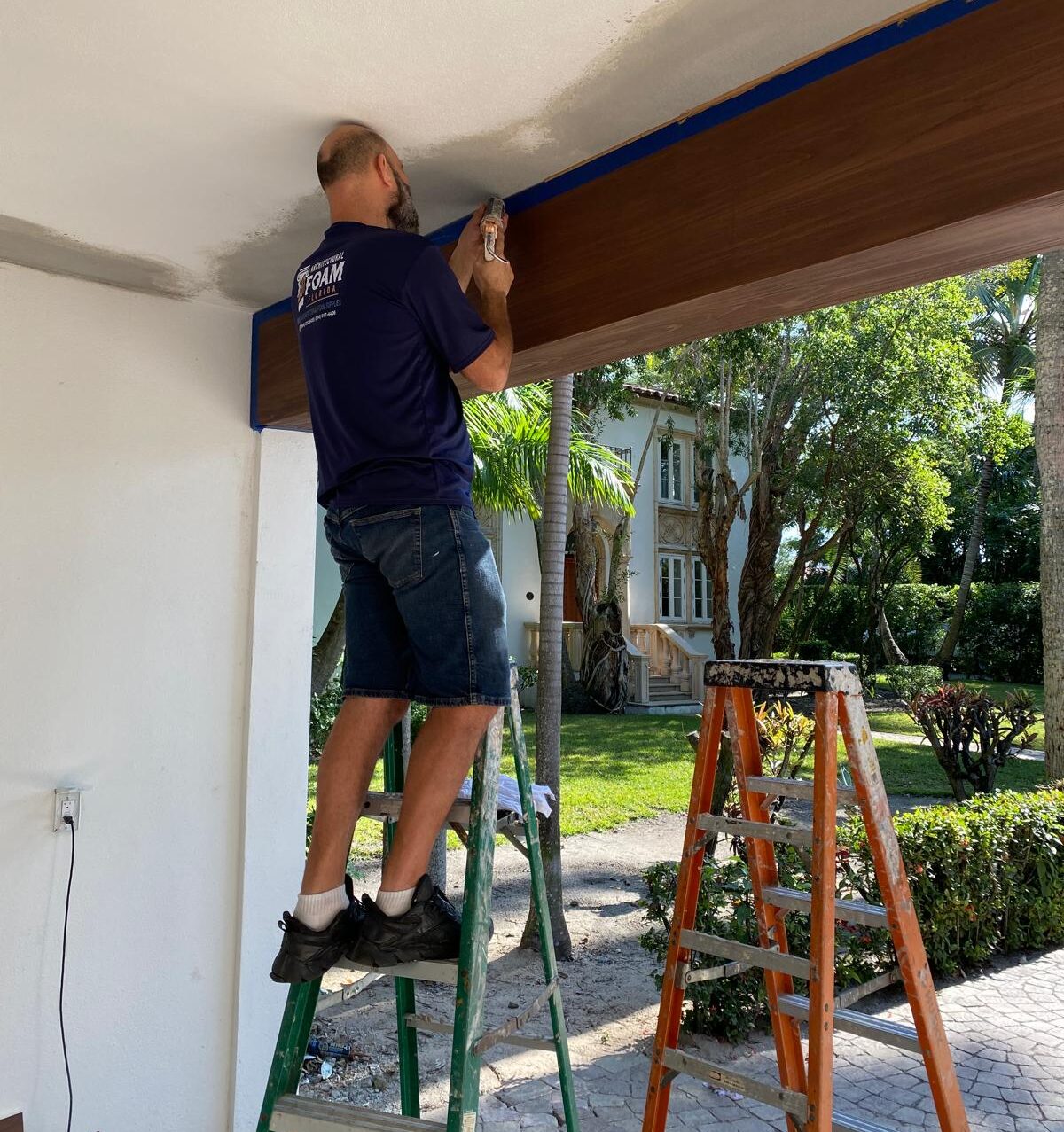 Installer setting a foam beam at a home entrance